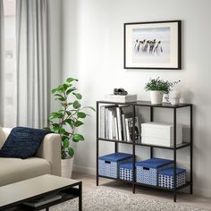 a living room filled with furniture and a book shelf next to a window on top of a hard wood floor