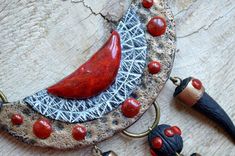 This statement tribal necklace is a really unique and unusual piece of jewelry made of polymer clay and different mediums.It is inspired by the African ethic jewelry with all its wild beauty and natural power.The main colors of the necklace are black and bronze, but red accents make it really bright and eye-catching. The red "gems" are covered with hard and durable enamel with a magic effect of tiny golden parts inside.The central element is held by two crocodiles - animals that symbolize courag Handmade Red Clay Jewelry, Handmade Bohemian Clay Jewelry, Handmade Red Artsy Necklaces, Handmade Red Artsy Necklace, Hand Painted Bohemian Clay Jewelry, Bohemian Hand Painted Clay Jewelry, Unique Red Polymer Clay Necklace, Unique Handmade Clay Jewelry, African Crocodile