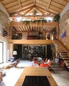 a living room filled with lots of furniture next to a fire place under a wooden ceiling