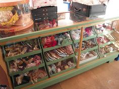 a green dresser with drawers filled with lots of shoes and other items on top of it