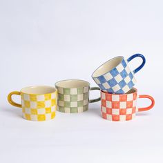 three different colored cups sitting next to each other