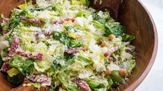 a wooden bowl filled with lots of salad