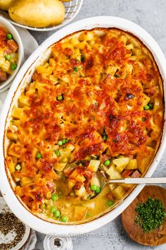 a casserole dish with peas, potatoes and meat in it on a table