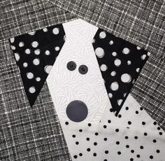 a black and white dog with polka dots on it's collar is made out of fabric