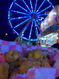 doughnuts in pink and white checkered paper with ferris wheel in background