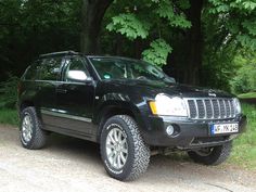 a black jeep parked in front of some trees