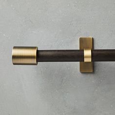 a close up of a metal and wood handle on a gray wall with concrete background