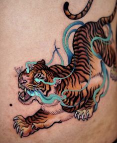 a tiger tattoo on the side of a woman's stomach, with blue lines running through it