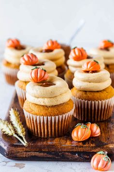 pumpkin cupcakes with cream cheese frosting and mini pumpkins on the side