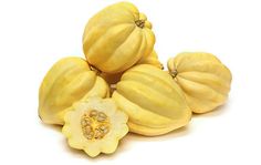 a group of yellow pumpkins sitting next to each other on top of a white surface