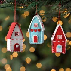 three felt houses hanging from a christmas tree