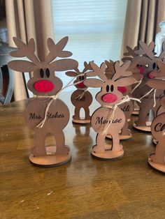 wooden reindeer decorations with names on them sitting on a table