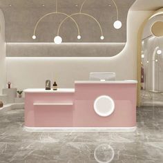 a pink reception counter in an office with round lights and circular chandeliers hanging from the ceiling