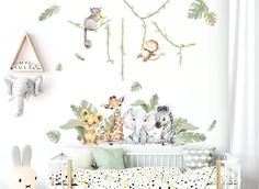 a baby's room with animals and plants on the wall, including a crib