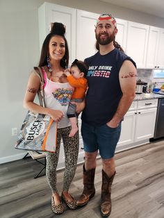 a man standing next to a woman holding a baby