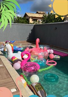 an inflatable pool with flamingos and balloons floating on the water next to a palm tree