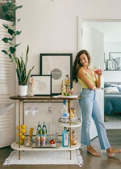 a woman standing next to a bar with drinks on it