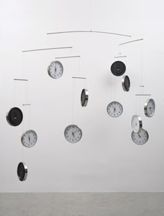 a group of clocks hanging from the side of a wall