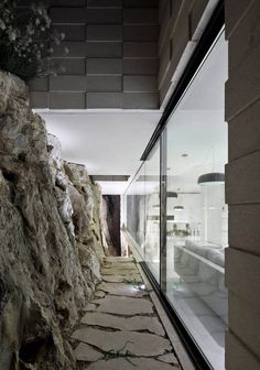 a stone walkway between two buildings with glass walls