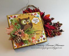 an owl is sitting on top of a card with fall leaves and flowers around it