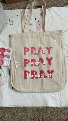 a canvas bag with the words pray pray and paint splattered all over it