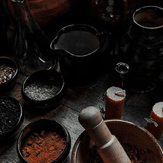 various spices and seasonings in bowls on a wooden table with an old fashioned grinder