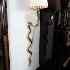 a lamp that is next to a wall with a snake design on it and a mirror behind it