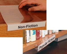 there is a book shelf with books on it and a person's hand touching the cover