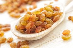 raisins in a spoon on a wooden table