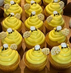 there are many cupcakes with yellow frosting on the top and bee decorations