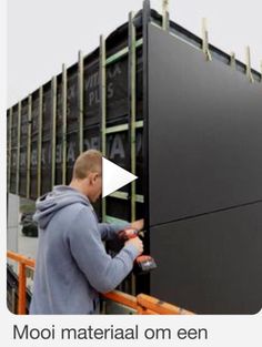 a man is working on a large black object