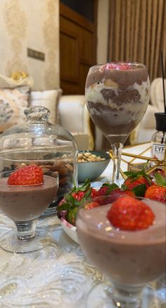 two desserts sit on a table with strawberries and other foods in bowls next to each other