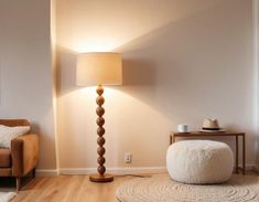 a living room with a chair, lamp and rugs on the hardwood flooring