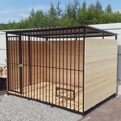 a wooden and metal fenced in area next to a building