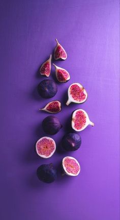 figs on a purple surface with one cut in half