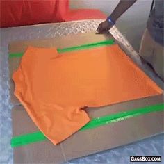 someone is cutting paper with a knife on top of some material that has been cut into squares