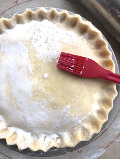 a pie crust with a red spatula in it sitting on top of a pan