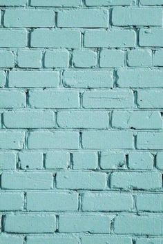 a blue brick wall that is painted in different shades