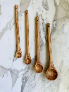 three wooden spoons sitting on top of a marble counter