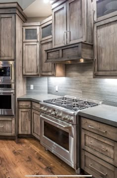 a kitchen with wooden cabinets and stainless steel stove top oven in the center of the room