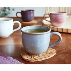 two cups of tea sit on a coaster