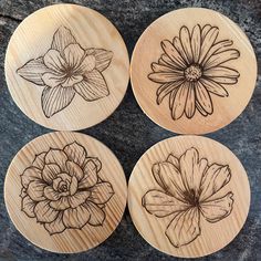 four wooden coasters with flowers drawn on them