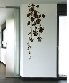 the wall is decorated with black and white flowers in an open hallway area that has glass doors leading to another room