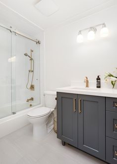 a bathroom with a toilet, sink, and shower stall is shown in this image