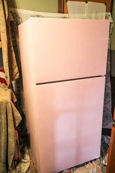 a pink refrigerator sitting in the corner of a room