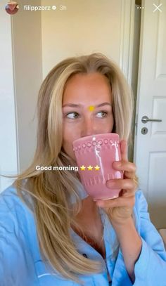 a woman holding a pink cup in front of her face with the words good morning on it