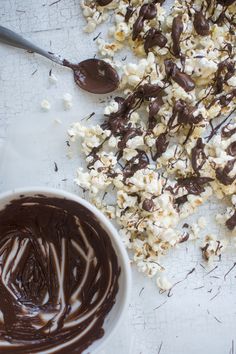 chocolate and marshmallows are on the table next to a bowl of popcorn