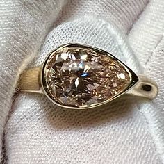 a fancy ring is sitting on top of a white towel with a diamond in the center