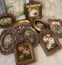 there are many pictures and frames with flowers on them in the picture frame set up