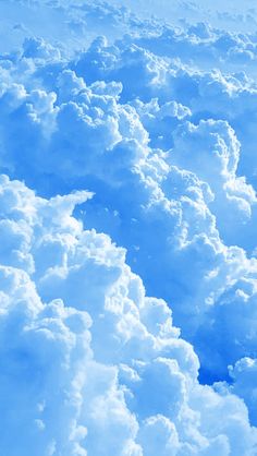 the view from an airplane window looking down on some fluffy white clouds and blue sky